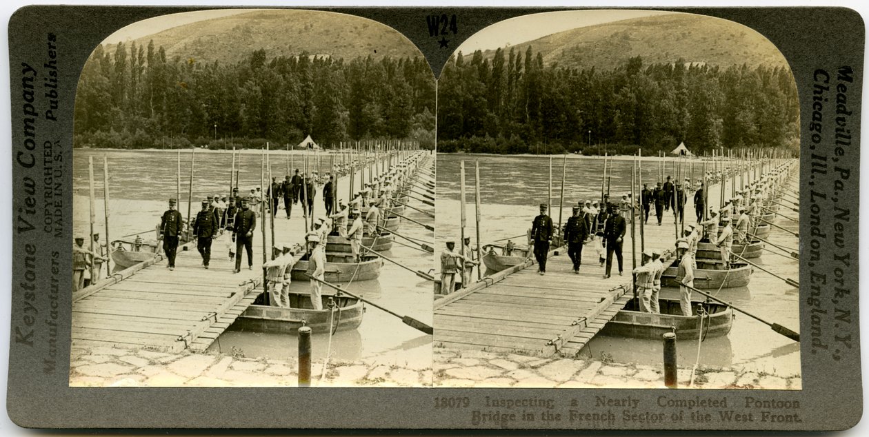Horizontale, sepia stereokaart met officieren in uniform die een pontonbrug oversteken met mannen die in de pontons aan weerszijden van de brug staan. Keystone Stereograph nummer 18079 door Keystone View Company