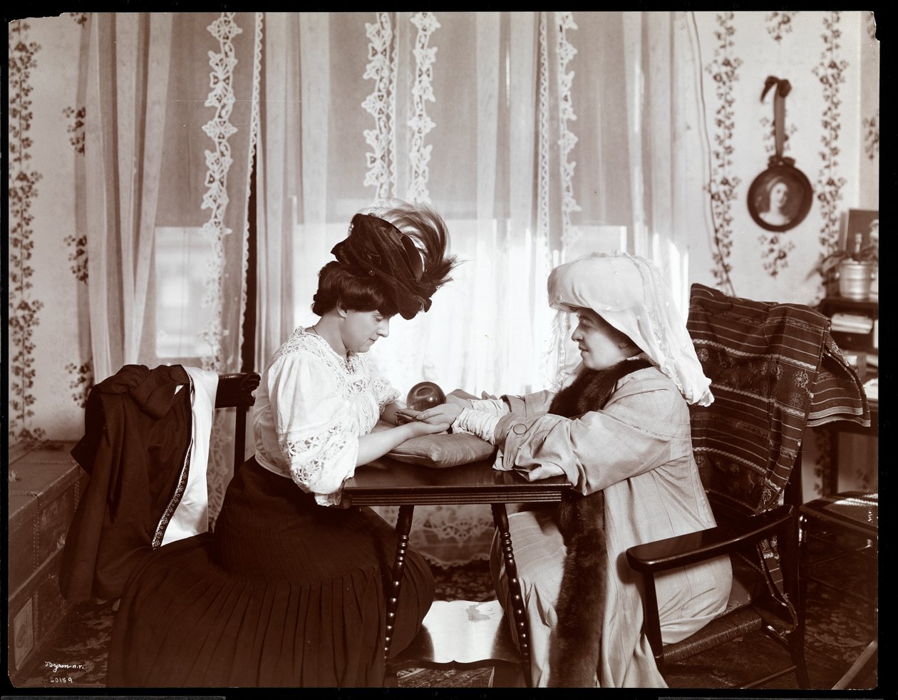 Mevrouw Leslie Carter zittend met een vrouw die een kristallen bol leest, 1904 door Byron Company
