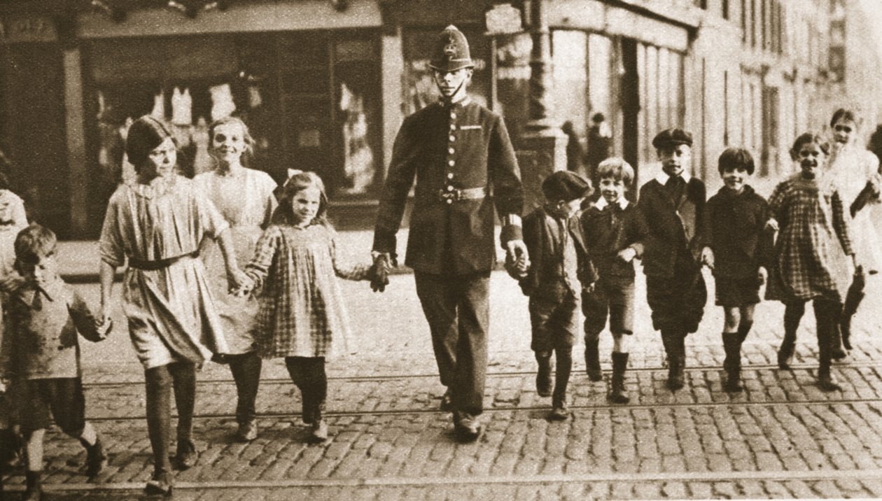Een agent die kinderen helpt oversteken aan het einde van de schooldag, uit Wonderful London, gepubliceerd 1926-27 door English Photographer