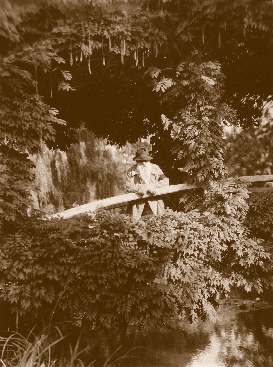 Claude Monet op de Japanse brug in zijn tuin in Giverny, c.1920 door French Photographer