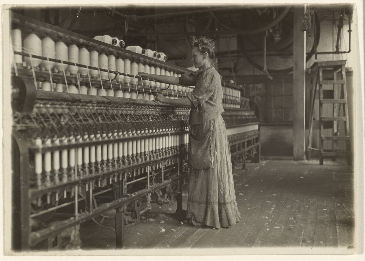 In een ouderwetse textielfabriek (spinner). door Lewis W. Hine
