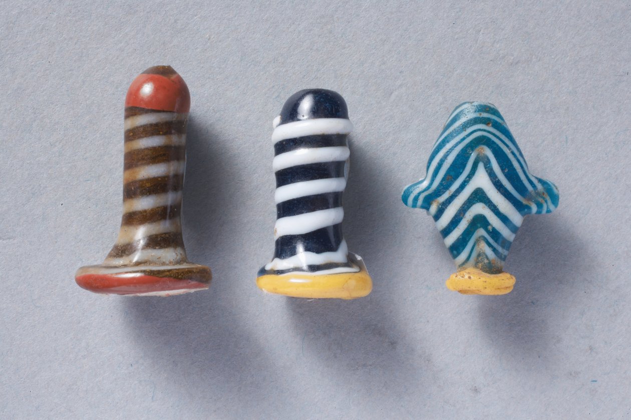 Twee glazen oorstekers en een Ib hart amulet door New Kingdom Egyptian