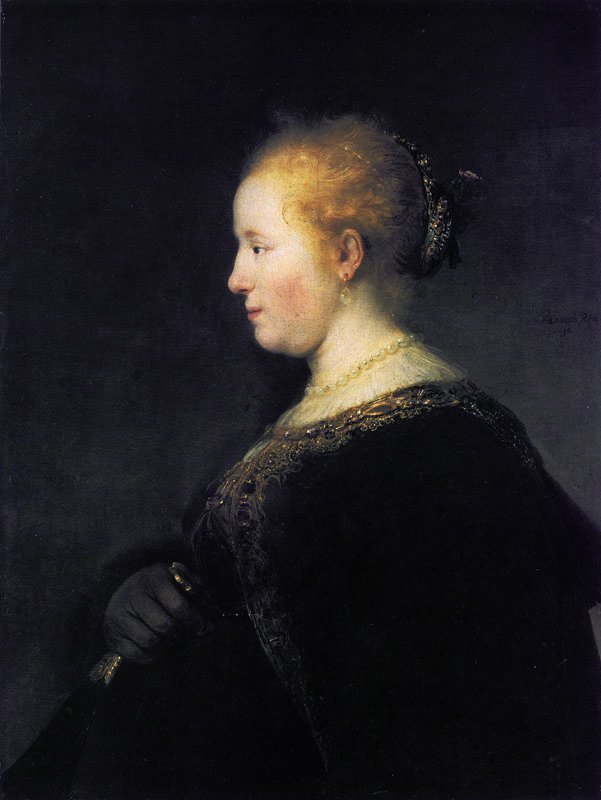 Een jonge vrouw in profiel met een waaier door Rembrandt van Rijn