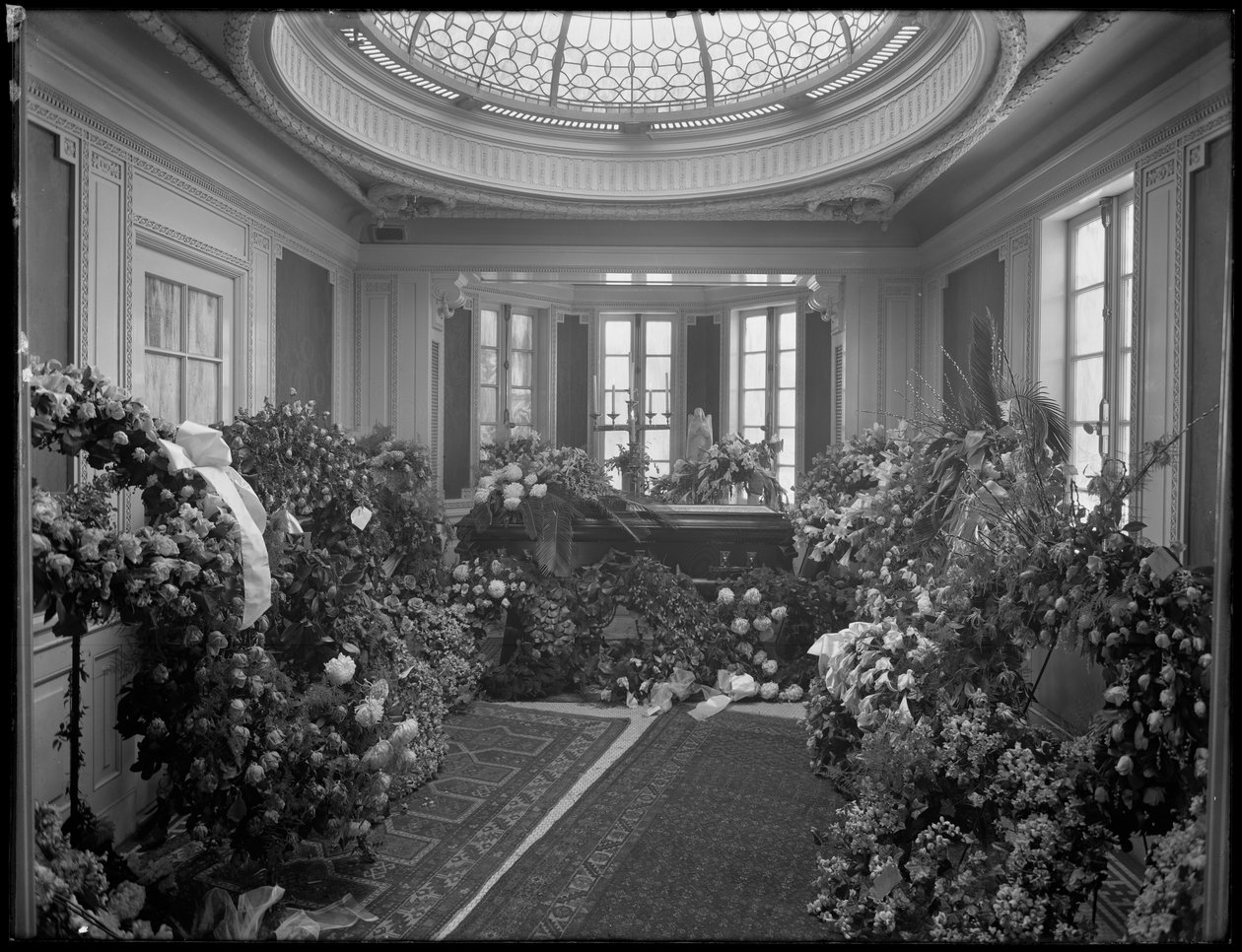 Ongeïdentificeerde begrafeniskapel interieur met kist en bloemen, versierd voor Octavio Davis, waarschijnlijk James E. McLarney, begrafenisondernemer, op 874 Lexington Avenue, New York City, 10 december 1915 door William Davis Hassler